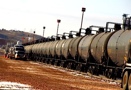 Trucks loading oil to tanker cars in North Dakota